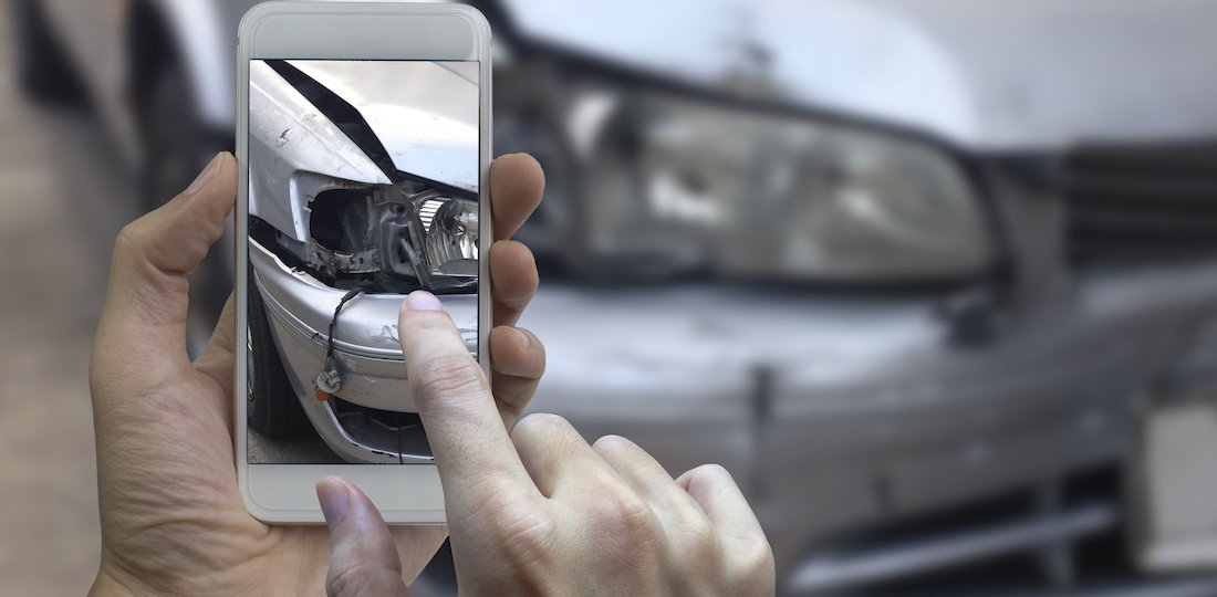 Hand holding smart phone take a photo at The scene of a car crash, car accident for insurance Car Accidents - ICBC